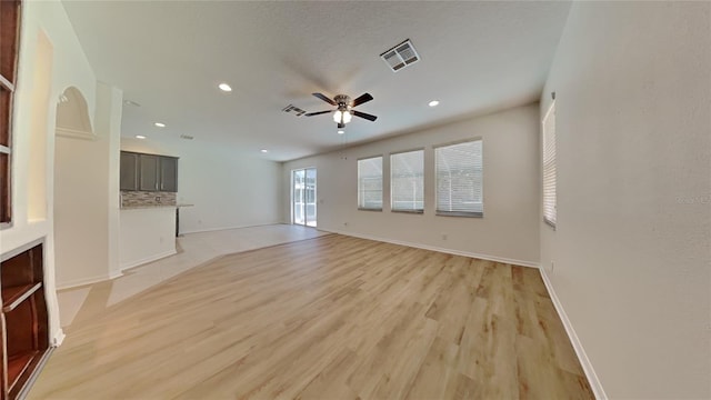 unfurnished living room featuring ceiling fan and light hardwood / wood-style flooring