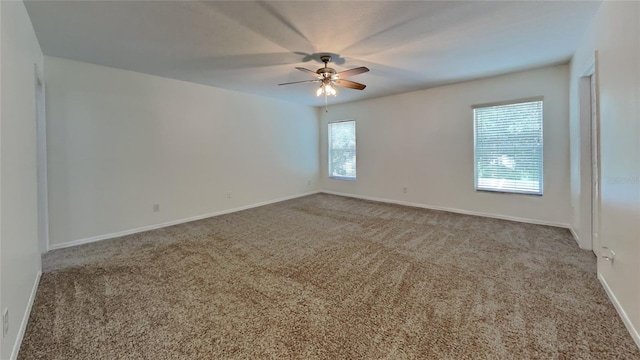 carpeted spare room featuring ceiling fan