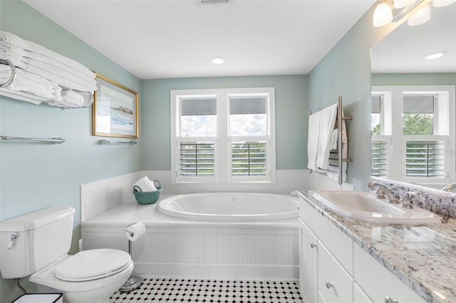 bathroom with vanity, a bath, and toilet