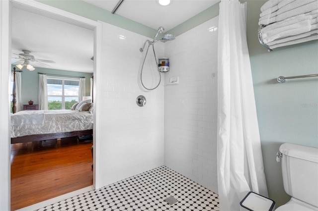 bathroom featuring ceiling fan, toilet, and walk in shower