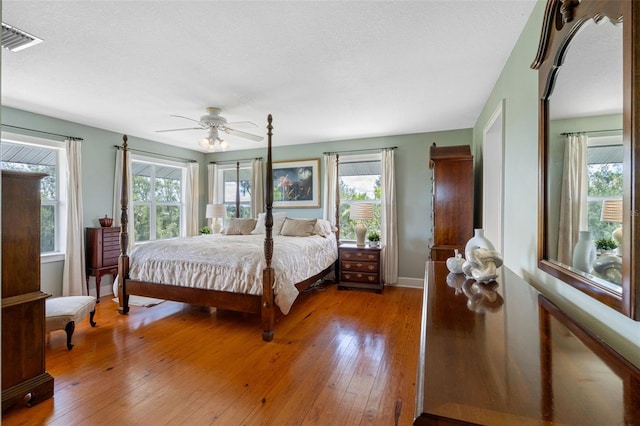 bedroom featuring multiple windows, ceiling fan, and light wood-type flooring