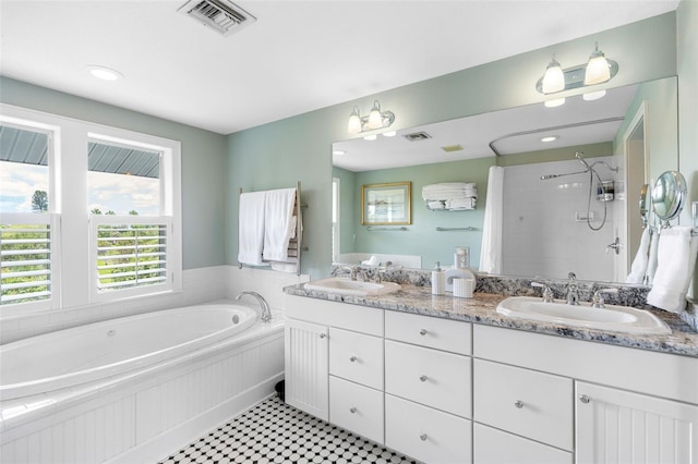 bathroom featuring plus walk in shower, vanity, and tile patterned flooring