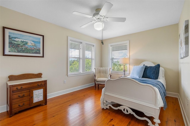 bedroom featuring ceiling fan, baseboards, and wood finished floors