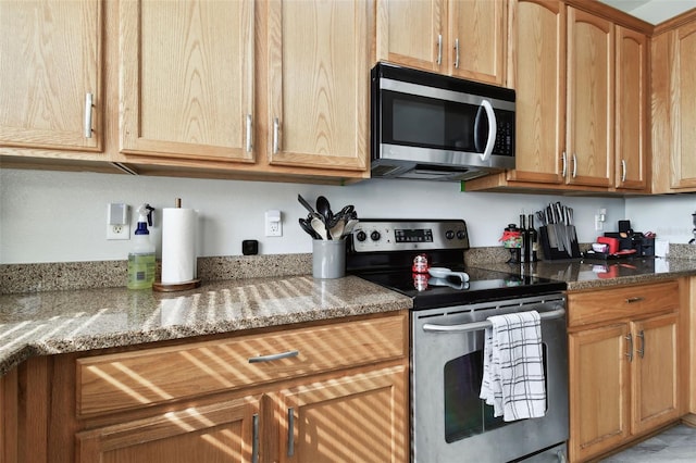 kitchen featuring stainless steel appliances and dark stone counters