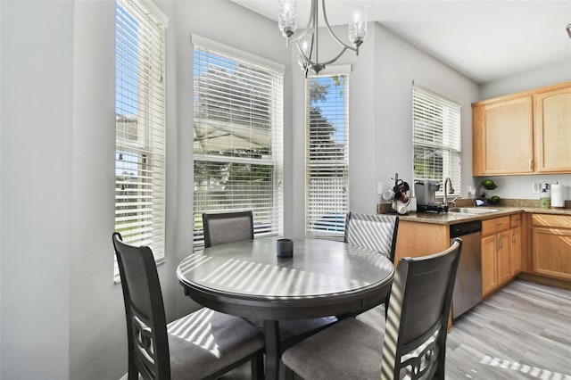 dining area featuring an inviting chandelier, light hardwood / wood-style floors, and sink