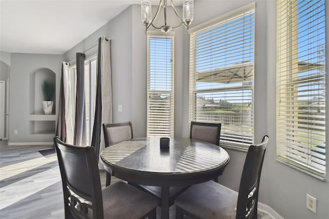 dining space featuring light hardwood / wood-style flooring and a notable chandelier