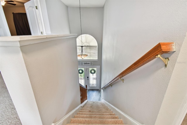 stairway featuring a high ceiling, carpet, and ceiling fan