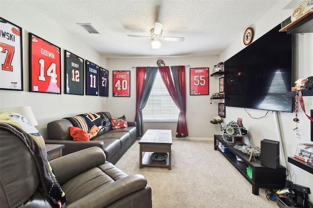 carpeted living room with ceiling fan and a textured ceiling