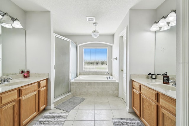 bathroom with a textured ceiling, shower with separate bathtub, and vanity