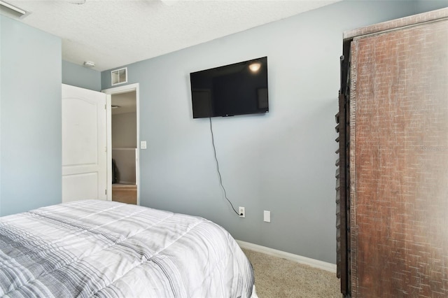 bedroom featuring carpet floors and a textured ceiling