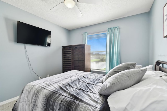 carpeted bedroom featuring ceiling fan and a textured ceiling