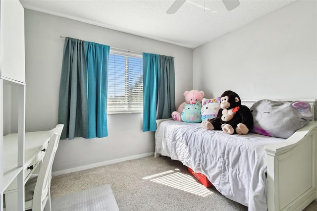 carpeted bedroom with ceiling fan and a textured ceiling