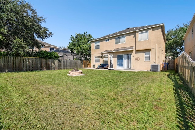 back of house featuring a patio, cooling unit, a yard, and a fire pit