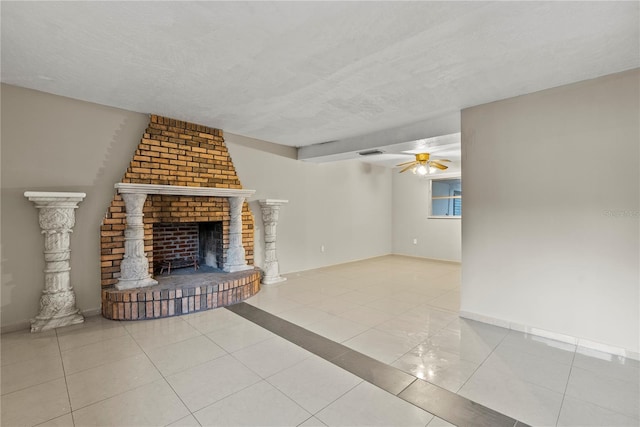 unfurnished living room featuring ceiling fan, a textured ceiling, a fireplace, and light tile patterned flooring