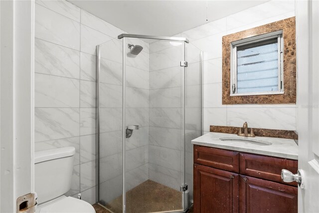 bathroom featuring tile walls, vanity, toilet, and an enclosed shower