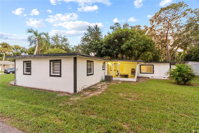 back of property with cooling unit, a yard, and a patio area