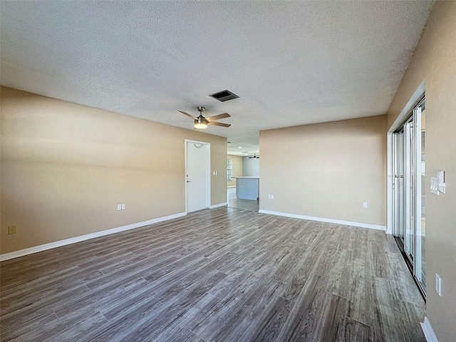 interior space with baseboards, visible vents, dark wood-style flooring, ceiling fan, and a textured ceiling