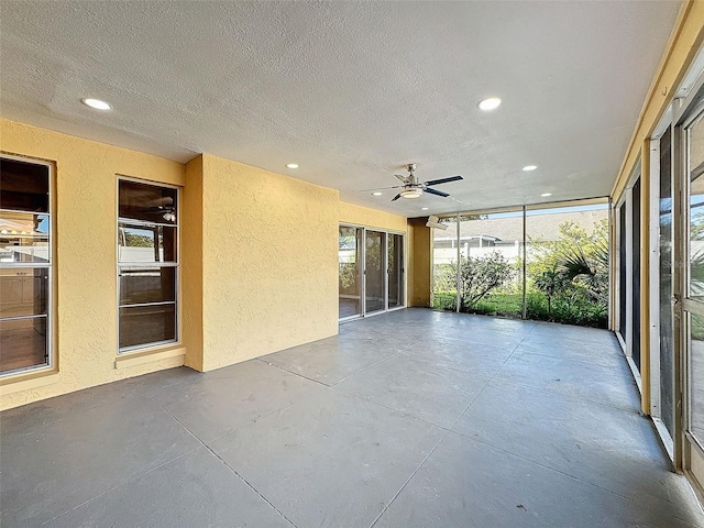 unfurnished sunroom with ceiling fan