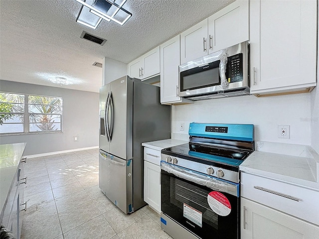 kitchen featuring stainless steel appliances, white cabinets, a textured ceiling, and light countertops