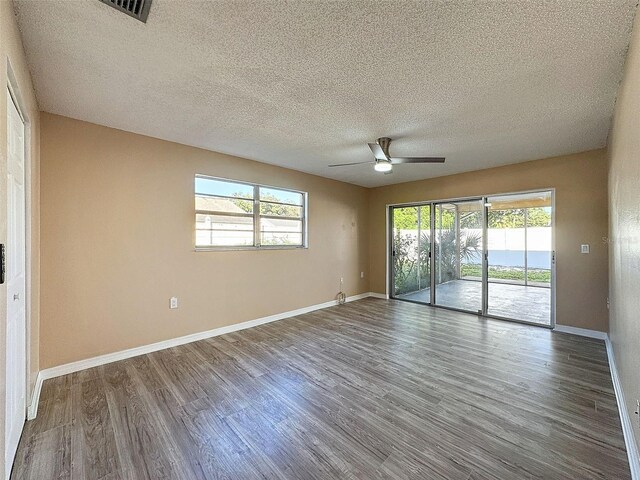 spare room with plenty of natural light, baseboards, and wood finished floors