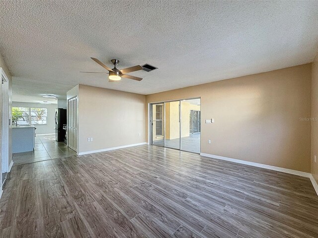 spare room featuring visible vents, baseboards, and dark wood finished floors