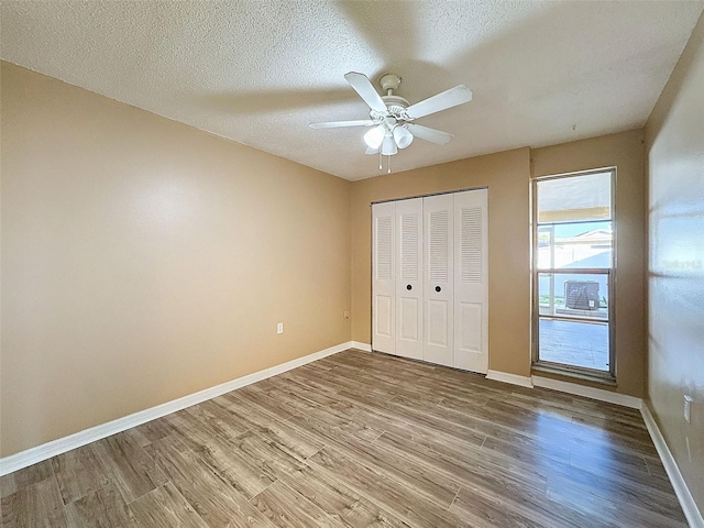 unfurnished bedroom featuring a closet, baseboards, and wood finished floors