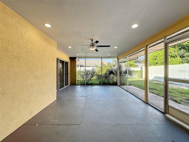 unfurnished sunroom featuring a wealth of natural light and ceiling fan