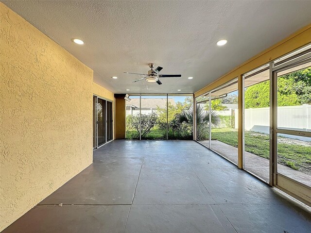 unfurnished sunroom featuring a ceiling fan