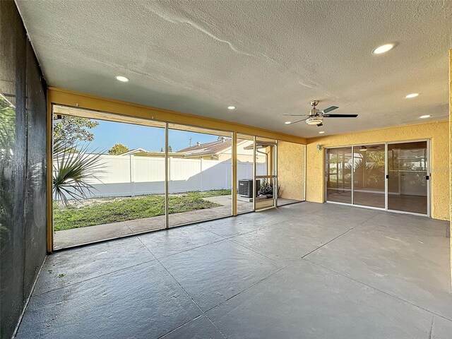 unfurnished sunroom with ceiling fan