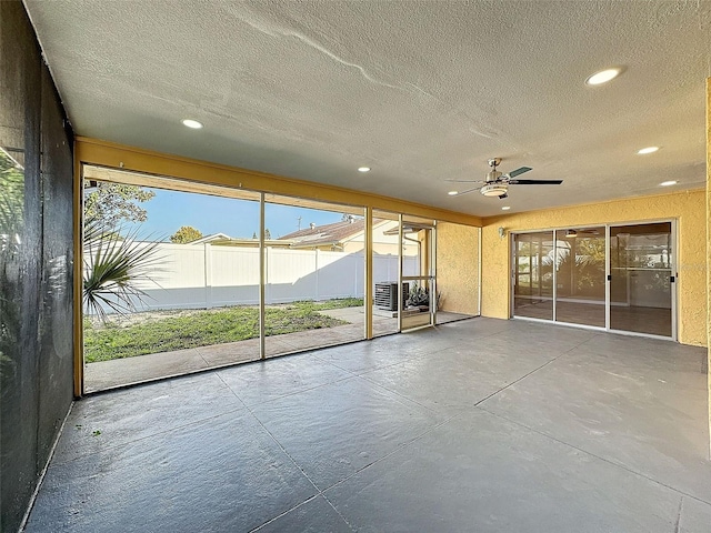 unfurnished sunroom featuring a ceiling fan