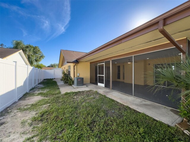 back of property featuring stucco siding, cooling unit, a yard, a fenced backyard, and a patio area