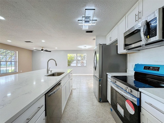 kitchen featuring a sink, plenty of natural light, appliances with stainless steel finishes, and white cabinetry