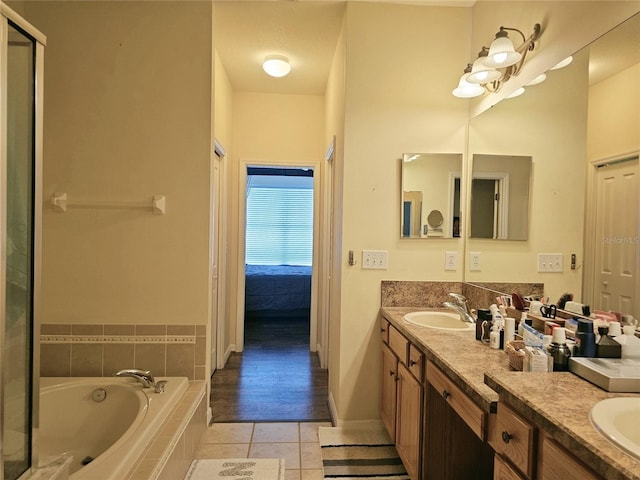 bathroom with vanity, tile patterned floors, and tiled tub