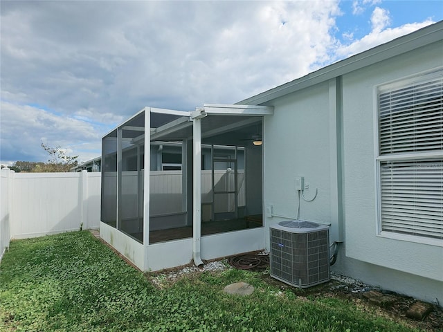 view of side of home with a sunroom and central AC