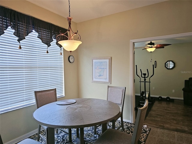 dining room with dark wood-type flooring, a healthy amount of sunlight, and ceiling fan