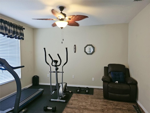 exercise room with a textured ceiling, dark hardwood / wood-style flooring, and ceiling fan