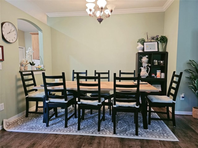 dining area featuring dark wood-type flooring, crown molding, and an inviting chandelier