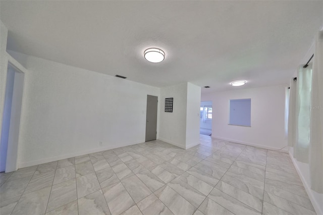 3908 W Wallace Ave, Tampa, FL 33611 - unfurnished room featuring visible vents, marble finish floor, and baseboards