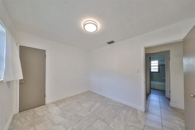 3908 W Wallace Ave, Tampa, FL 33611 - spare room with marble finish floor, baseboards, and visible vents
