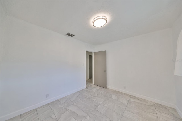 3908 W Wallace Ave, Tampa, FL 33611 - empty room with marble finish floor, visible vents, and baseboards