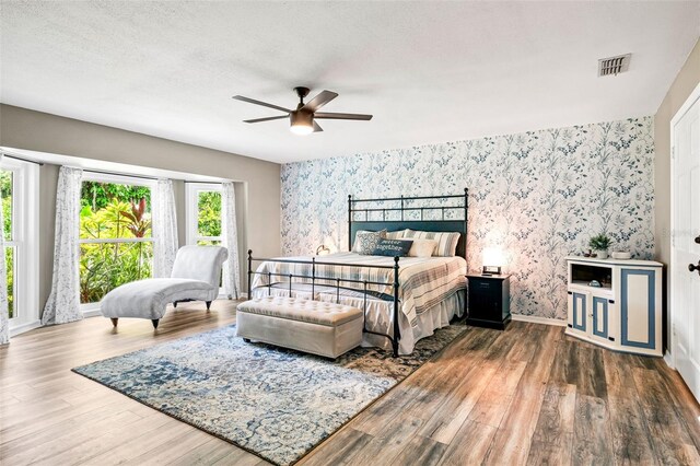 bedroom featuring multiple windows, ceiling fan, and dark hardwood / wood-style flooring