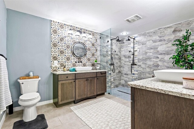 bathroom featuring tile patterned floors, a shower with shower door, toilet, and vanity