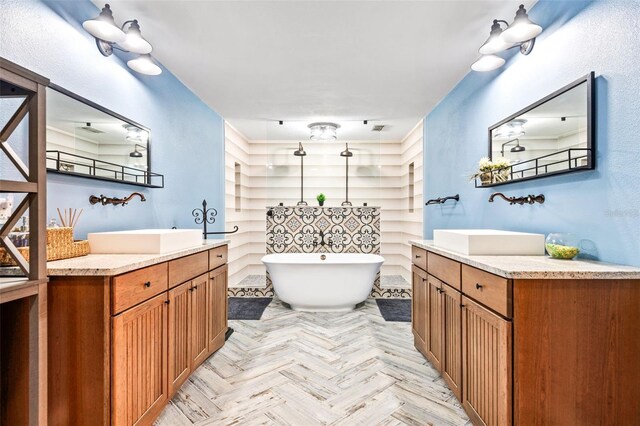 bathroom featuring vanity, a bathing tub, and parquet floors