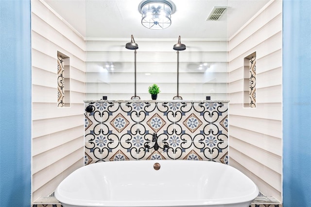 bathroom featuring a freestanding tub, visible vents, and a walk in shower