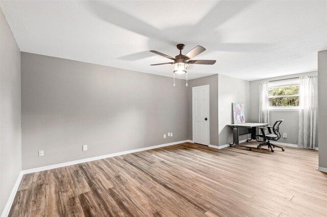 unfurnished office with light wood-type flooring and ceiling fan