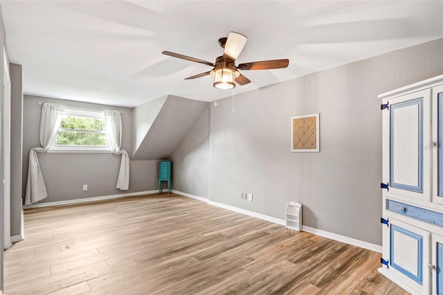 additional living space with a ceiling fan, lofted ceiling, baseboards, and wood finished floors