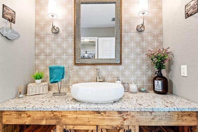 bathroom featuring vanity, tasteful backsplash, and tile walls