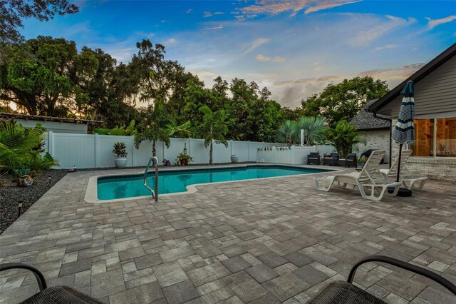 pool at dusk with a patio