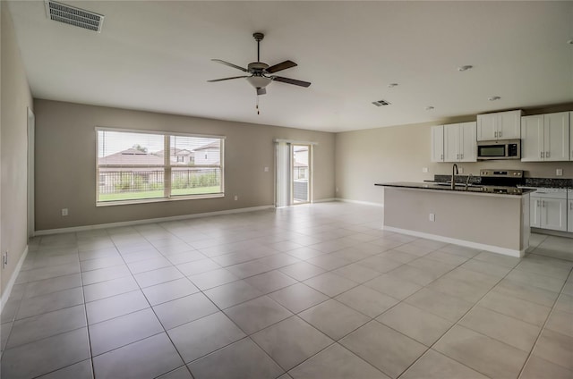 kitchen with ceiling fan, appliances with stainless steel finishes, white cabinets, and light tile patterned flooring