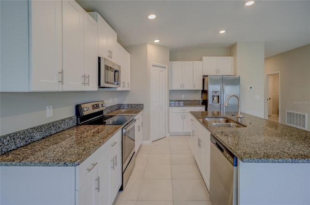 kitchen with a kitchen island with sink, appliances with stainless steel finishes, white cabinetry, and sink